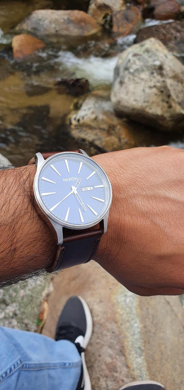 Man hiking in nature while showing off his Sentry Leather analog watch